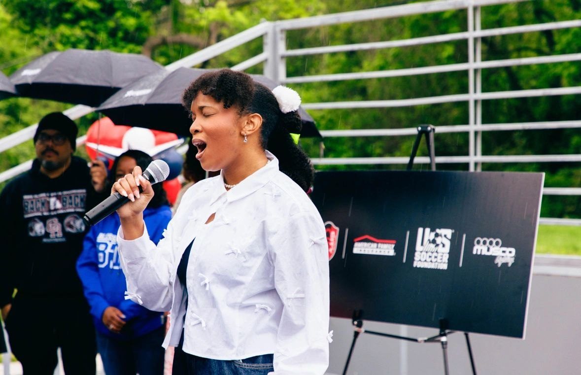 Florie singing the national anthem at the Ferguson mini pitch opening